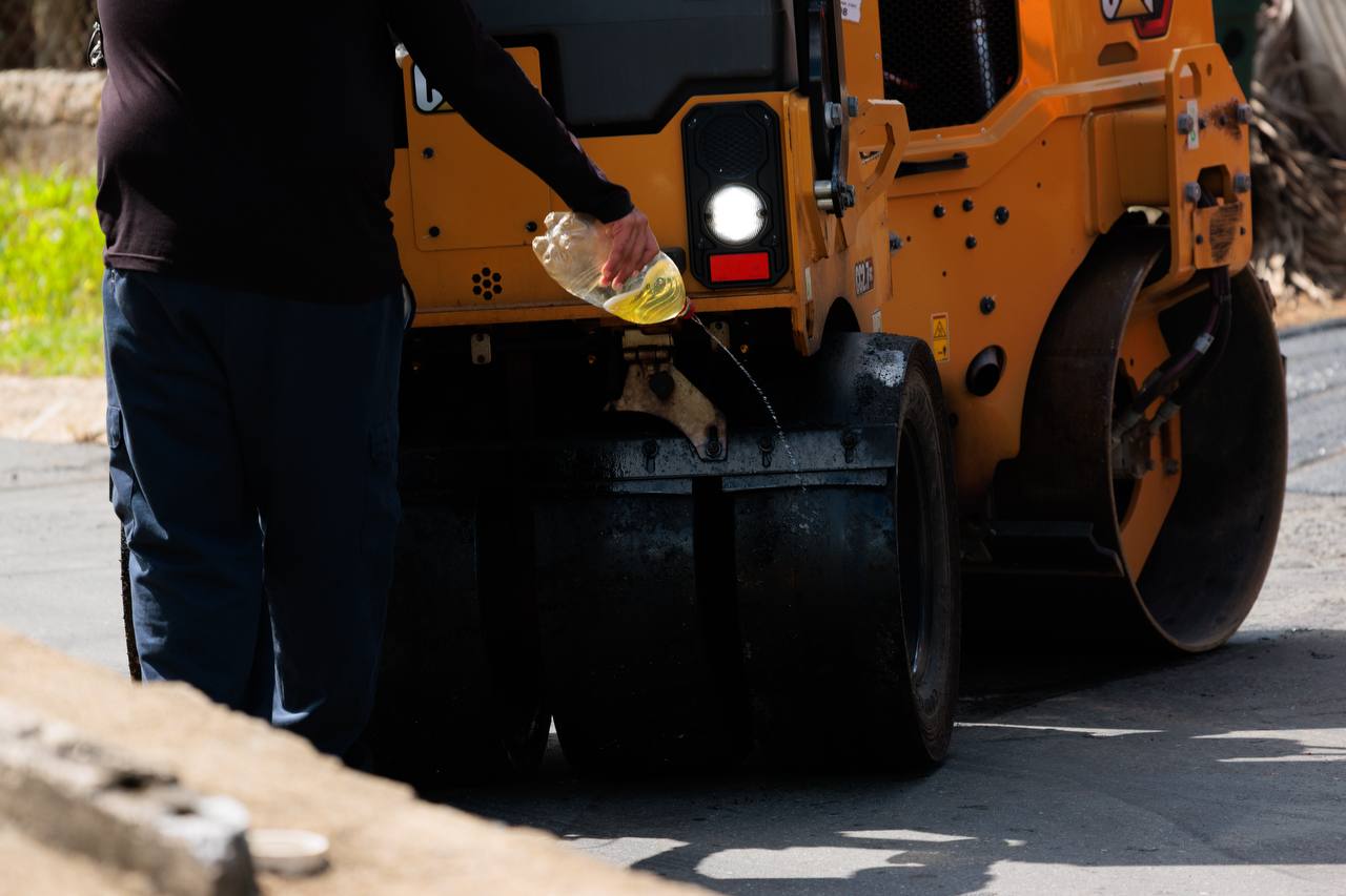 Operador dando mantenimiento al rodillo compactador durante los trabajos